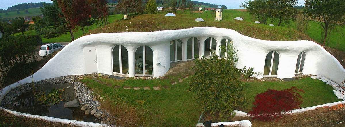 White curved earth houses with grass growing over their roofs